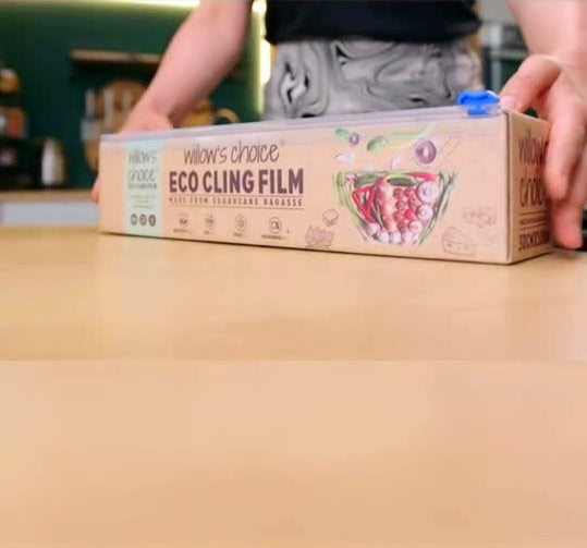 Hand holding Willow's Choice eco cling film on table