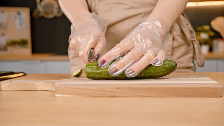 Cutting cucumber with eco gloves 